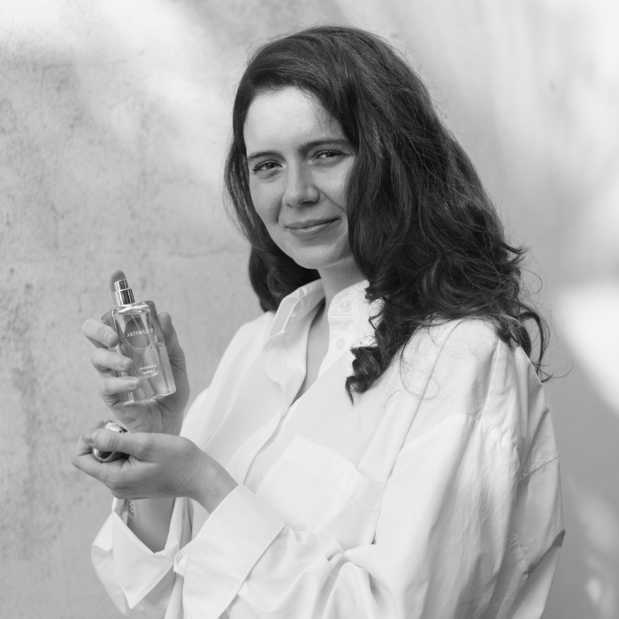 Portrait de Sara Marzocchini, fondatrice des parfums ARTIMIQUE, qui tient un flacon de parfum dans la main