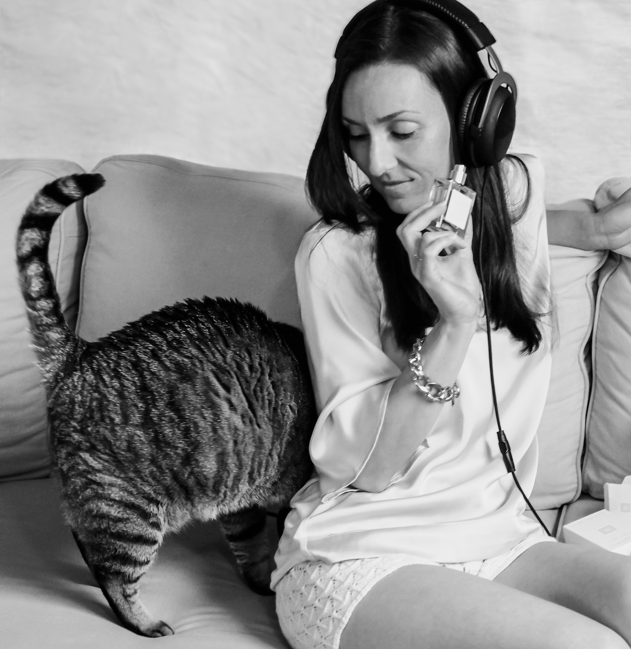 La fondatrice de Marylise Mirabelli. Elle est assise sur un canapé, un chat passe derrière elle. Elle a des écouteurs hifi sur les oreilles.