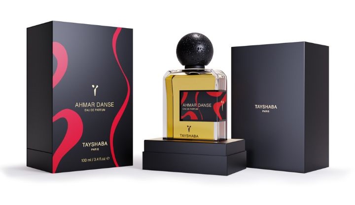 Un flacon de parfum Ahmar Danse de la marque TAYSHABA, placé dans son coffret ouvert. Il est vendu sur SCENTISSIME.