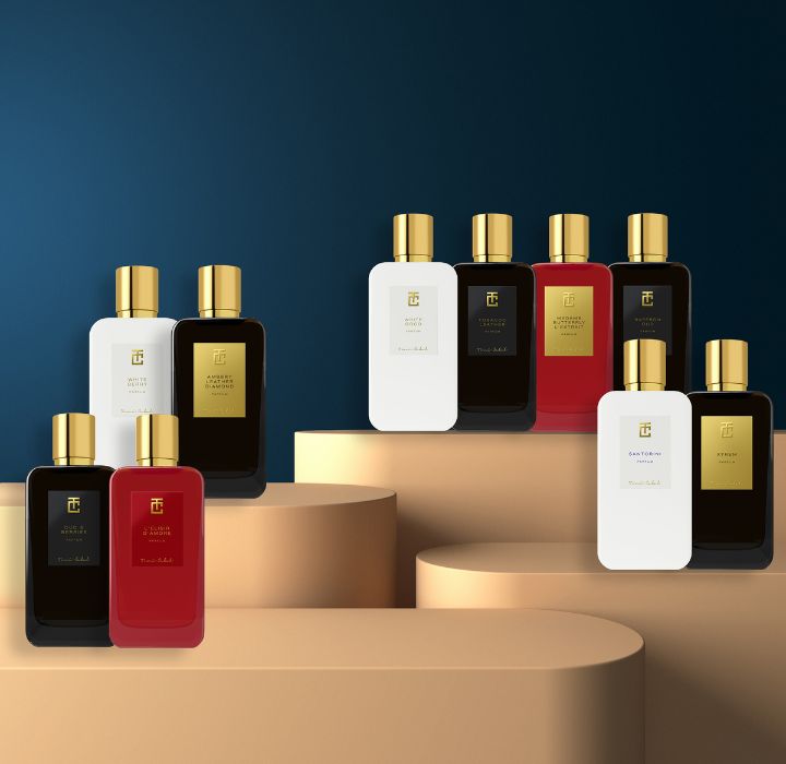 Une collection de flacons de parfum Toni cabal de différentes couleurs sur un fond bleu sombre