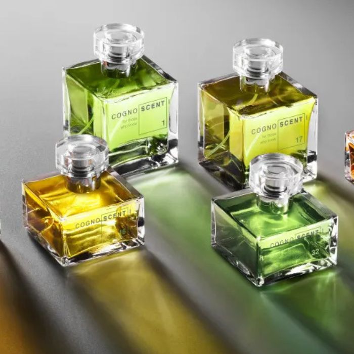 Flacons de parfums de niche verts et jaunes sur fond gris